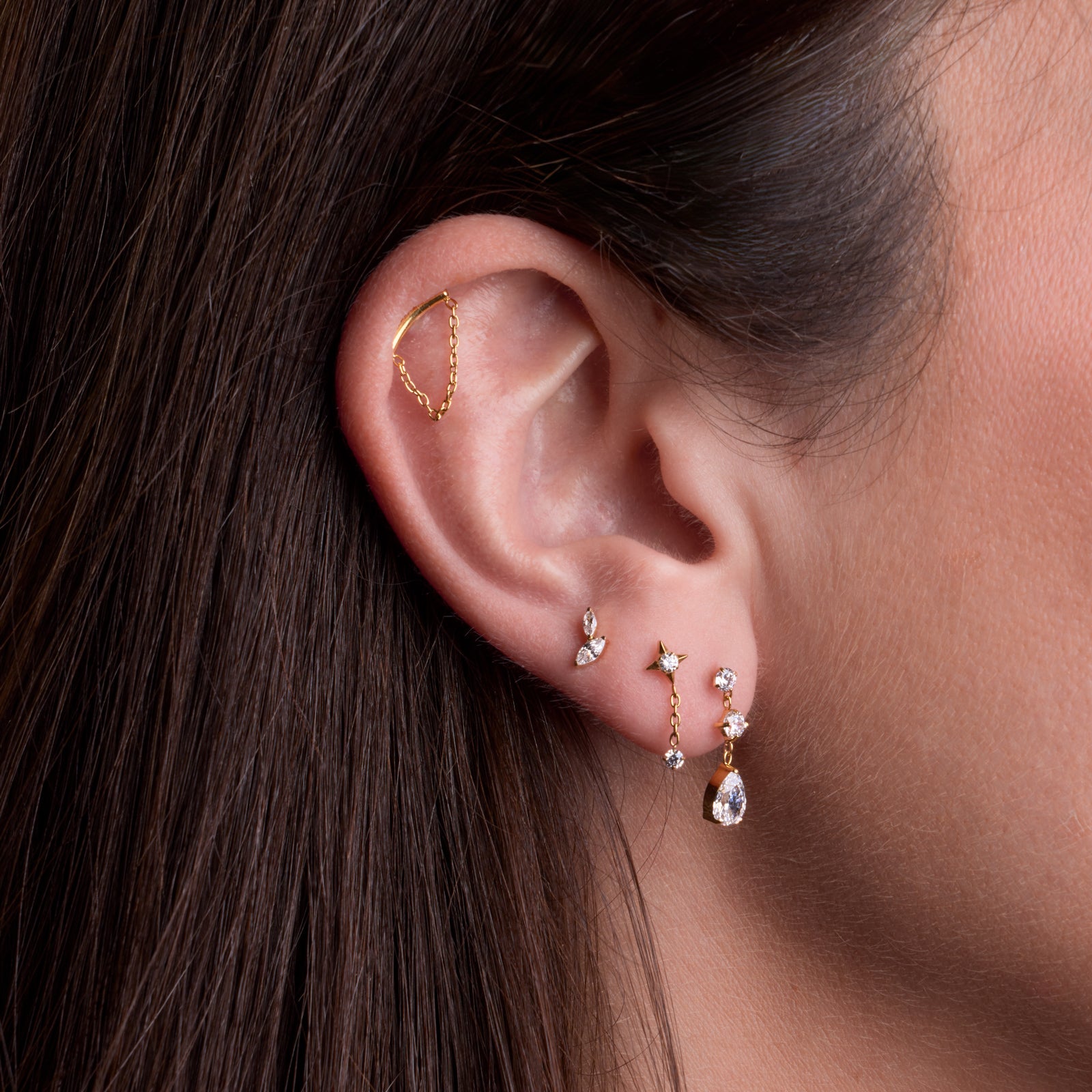 Composition de bijoux de piercing oreille en titane: Miraggio gold à l'hélix, Noisette blanc au 3ème lobe, Americano blanc au deuxième lobe, Lungo blanc au deuxième lobe.